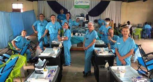 Group of people in a clinic wearing blue scrubs.